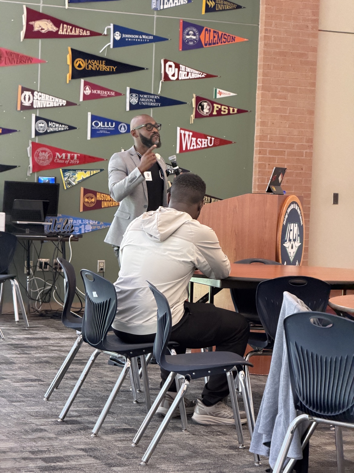 Bossman Daryl speaking at a school podium