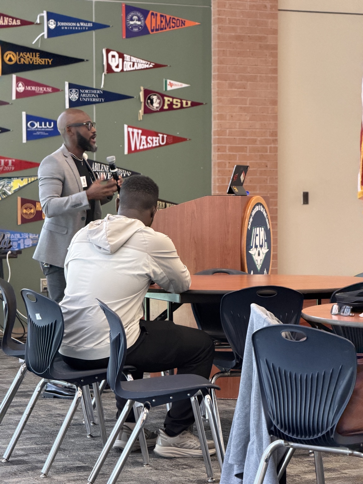 Bossman Daryl speaking at a school podium