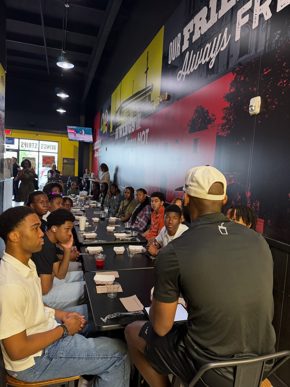 Bossman Daryl with youth at a WingIt restaurant