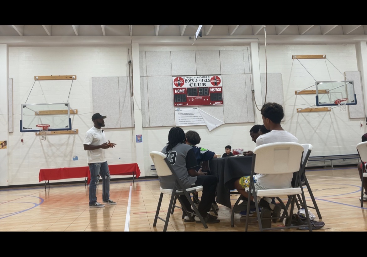 Bossman Daryl speaking at a Boys and Girls Club gym